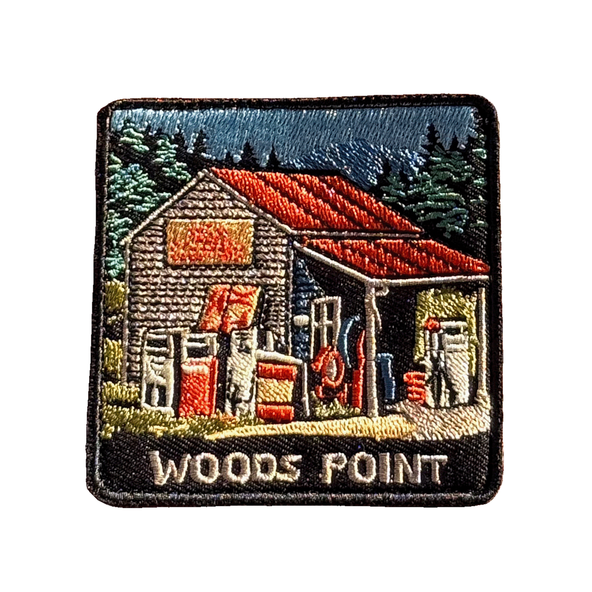 Woods Point embroidered travel patch with a rustic high-country petrol station with old fuel pumps among pine trees; photographed on a transparent background.