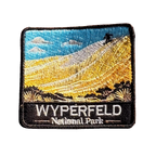 Wyperfeld National Park embroidered travel patch with a sandboarder on a towering pale sand dune above scrubland; photographed on a transparent background.